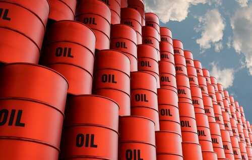 Stacked red oil barrels against a cloudy sky