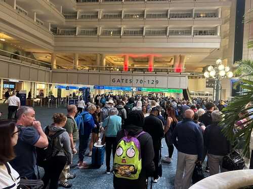 Crowd of travelers waiting in line at an airport terminal