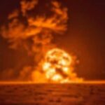 A large explosion creating a fireball and smoke cloud against a dark background
