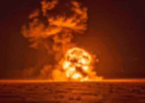 shutterstock_2623950711.jpg A large explosion creating a fireball and smoke cloud against a dark background