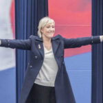A woman with outstretched arms at a political rally