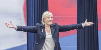 A woman with outstretched arms at a political rally
