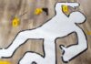 Outline of a body on the floor with evidence markers and tools nearby