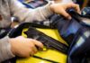 A person reaching into a backpack that contains a handgun