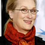 Smiling woman wearing glasses and a red scarf at an event