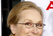 Meryl Streep Sparks Voter ID Firestorm Smiling woman wearing glasses and a red scarf at an event