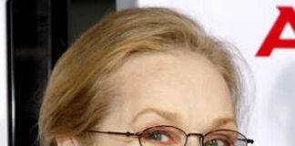 Smiling woman wearing glasses and a red scarf at an event