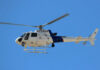 A U.S. Customs and Border Protection helicopter flying against a clear blue sky