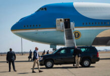 Airplane with stairs and people on the tarmac
