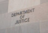 Department of Justice sign on building wall.