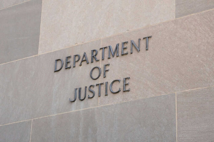 Department of Justice sign on building wall.