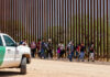Border Patrol vehicle near group of people walking