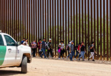 Border Patrol vehicle near group of people walking