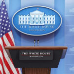 Podium with microphones in front of American flag