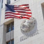 American flag waving in front of a United States court house