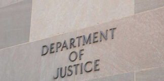 Department of Justice sign on building wall.