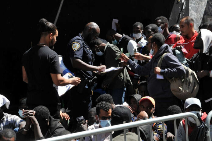 2341459001 Crowd of people near police officer holding papers