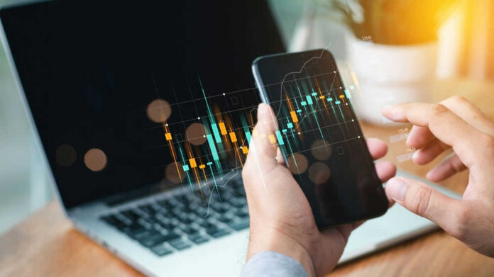 Hands holding phone with financial graph overlay