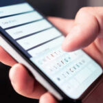 Close-up of a hand using a smartphone to enter information