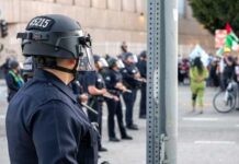 Dismembered Bartender Found — Two Nabbed Police officers in riot gear monitoring a protest