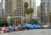 Street lined with tents and makeshift shelters downtown.