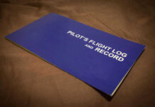 Blue pilots flight log and record book on table