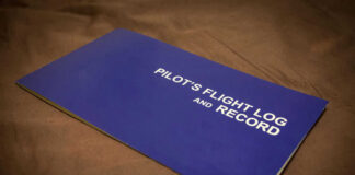 Blue pilots flight log and record book on table