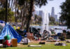 Homeless encampment in a park with a view of the Los Angeles skyline