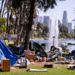 Homeless encampment in a park with a view of the Los Angeles skyline