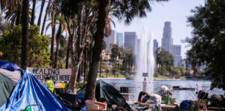 Homeless encampment in a park with a view of the Los Angeles skyline