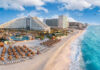 Beachfront resort with sand chairs and turquoise ocean water