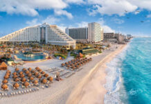 Beachfront resort with sand chairs and turquoise ocean water