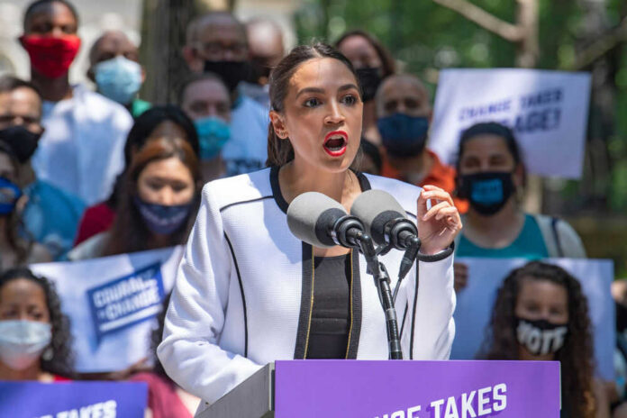 1987838789 Person speaking at a public event with crowd.