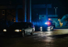 Nightclub Inferno Exposes Deadly Loopholes A police car with flashing lights parked next to a dark vehicle in a dimly lit urban area