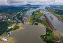 Aerial view of the Panama Canal with ships and surrounding landscape