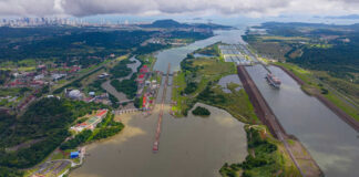 Aerial view of the Panama Canal with ships and surrounding landscape
