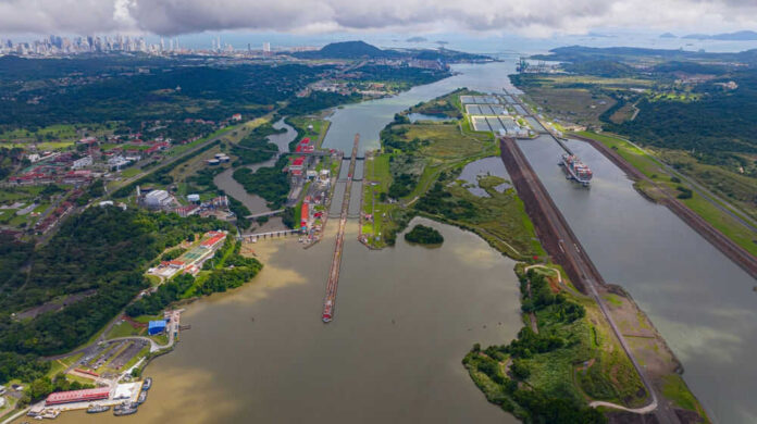 Aerial view of the Panama Canal with ships and surrounding landscape