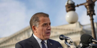 Man speaking at a podium with microphones outside
