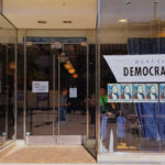 Storefront of Westside Democratic Headquarters with signs.