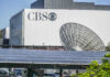 CBS building with large satellite dish and solar panels.