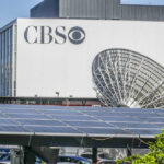 CBS building with large satellite dish and solar panels.