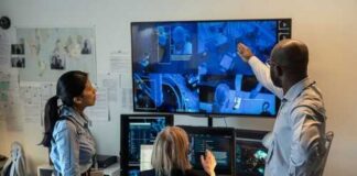 Three professionals analyzing security footage on multiple screens