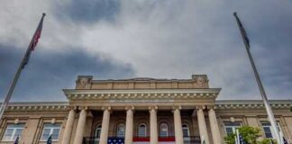 Historic building with large American flag and multiple flags in front