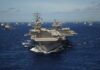 Top Gun Vet Maps Iran Endgame An aircraft carrier surrounded by a fleet of naval ships in the ocean