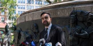 A man giving a speech at a podium in a city park