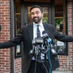 Royal Power Move Stuns Britain Man in a suit speaking at a press conference with microphones in front of him