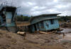 Tourist Selfies, Then Chaos A collapsed building and debris in a muddy area after a flood