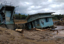 Tourist Selfies, Then Chaos A collapsed building and debris in a muddy area after a flood