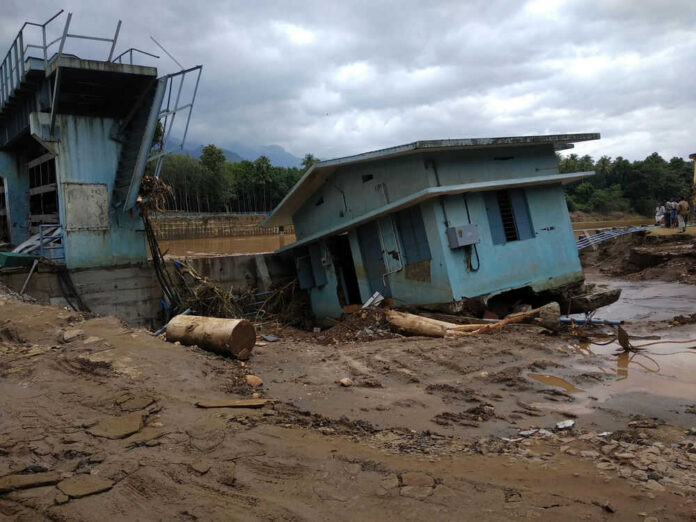 A collapsed building and debris in a muddy area after a flood