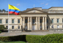 Stolen Identity Vote Sparks Federal Prison Historic building with Colombia flag in front.